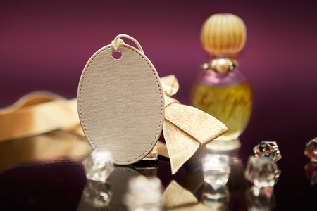 Empty key tag with yellow bow and yellow perfume in the backgroundの写真素材
