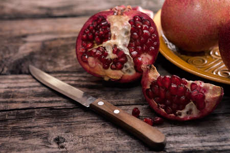 Peeled and sliced pomegranate with a knife on the tableの写真素材
