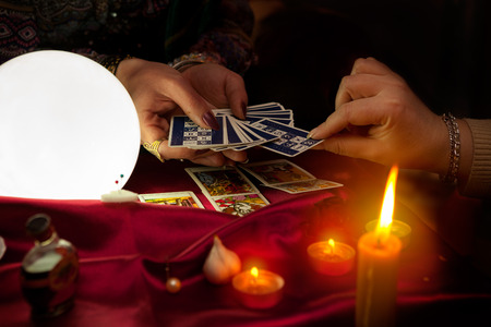 Tarot cards in hands of old gypsy fortune teller womanの写真素材