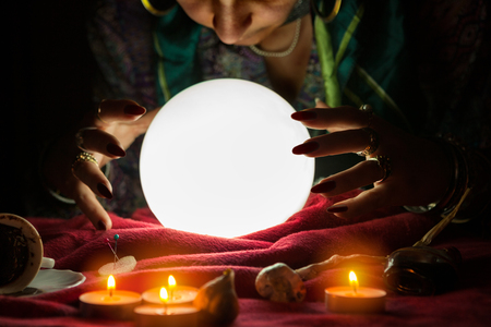 Fortune teller woman looking at shining crystal ballの写真素材