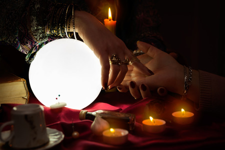 Woman fortune teller read a fortune from palmの写真素材