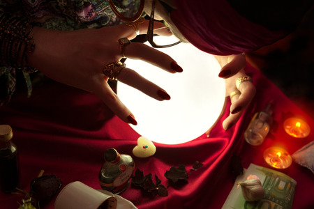 Gypsy woman fortune teller using crystal ball for predicting of futureの写真素材