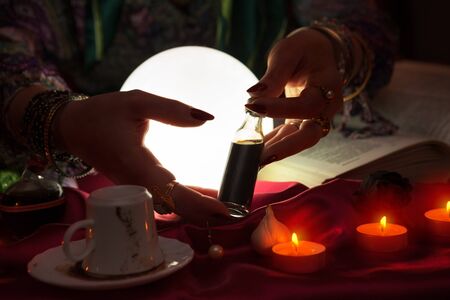 Hands of an gypsy fortune teller who holding love potionの写真素材