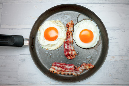 Top view on pan with fried egg with baconの写真素材
