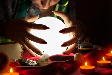 Old gypsy fortune teller with crystal ball predicting the futureの写真素材