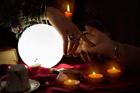 Woman fortune teller read a fortune from palmの写真素材