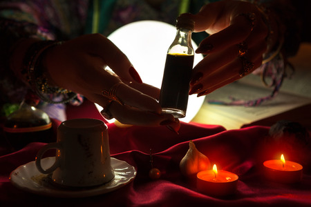 Hands of an gypsy fortune-teller holding love potionの写真素材
