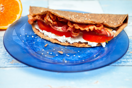 chrono pancakes with bacon and tomatoes on a plateの写真素材