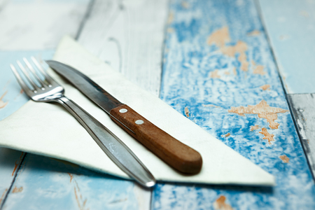 Fork and knife at napkin on wooden rustic backgroundの写真素材