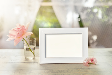 Frame mockup with flower in glass and petal on the tableの写真素材