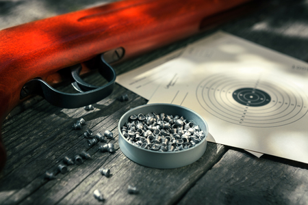 Pellets,air rifle and target on wooden tableの写真素材