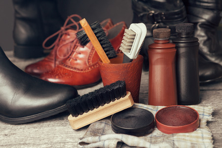 Brushes, cloth and polish cream for shoes and boots on wooden tableの写真素材