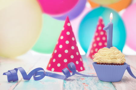 Birthday muffin,blowouts and party hats on the tableの写真素材