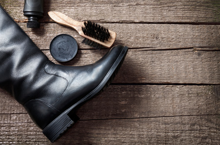 Black boot, polisher, brush and polishing cream on wooden backgroundの写真素材