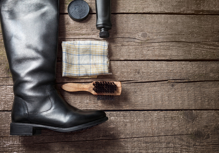 Polish cream, black boot,brush and dirty cloth on wooden backgroundの写真素材