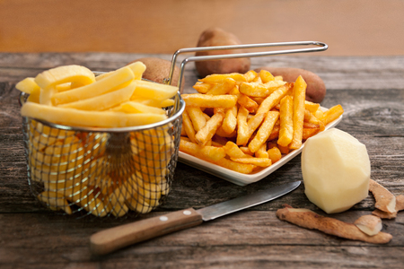 Potato in fry basket and french fries in plateの写真素材