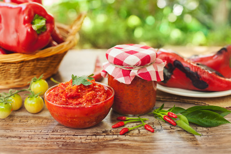 Ajvar in bowl and glass jar on the tableの写真素材