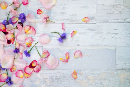 Colorful flowers and petals on wooden table