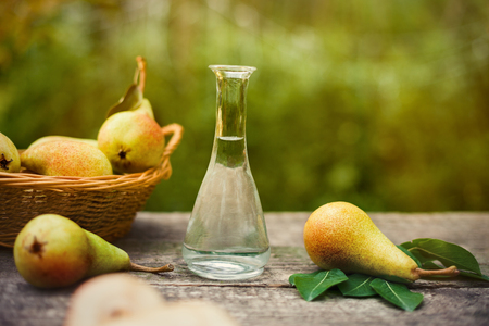 Fresh pear with bottle of fruit brandy on the tableの写真素材