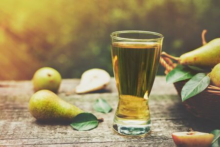 Glass of pear juice and ripe pears on the tableの写真素材