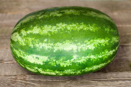 Single watermelon on wooden backgroundの写真素材