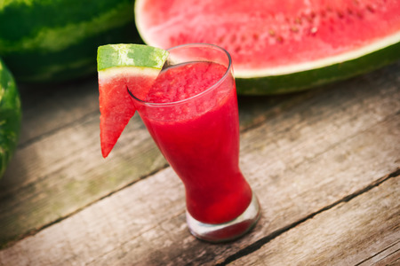 Cold watermelon cocktail in glass with watermelon sliceの写真素材