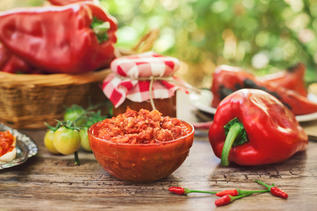 Appetizing Ajvar in bowl with red peppersの写真素材