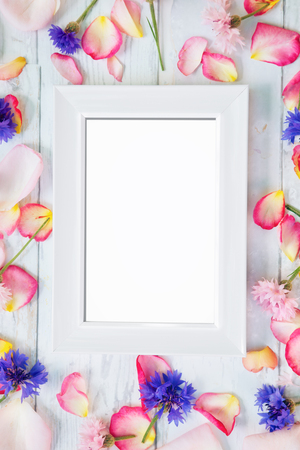 White empty frame with petals around frame on wooden backgroundの写真素材