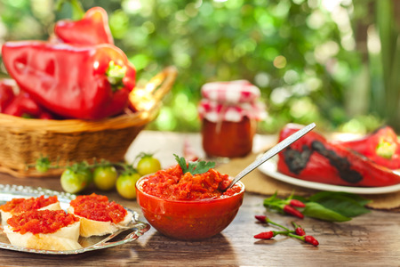Delicious ajvar in bowl with spoon on the tableの写真素材
