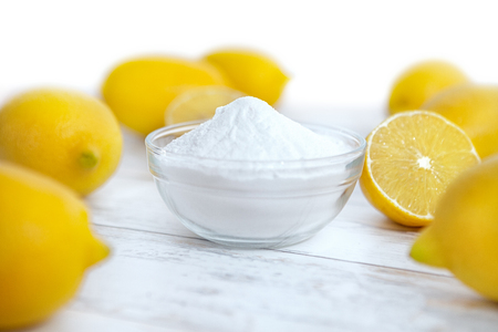 Baking soda in bowl with lemons on the tableの写真素材
