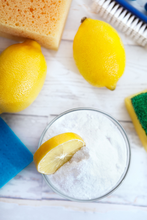 Natural cleaners, lemon and baking soda with sponges and cleaning brushの写真素材