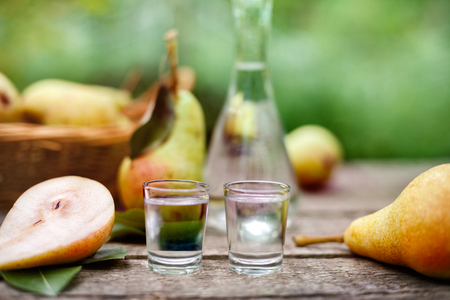Pear brandy in two shot glass with fresh sliced pearsの写真素材