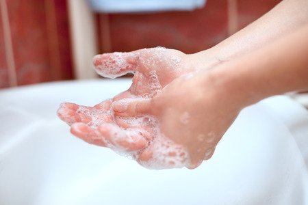 Hand hygiene. Soapy hands cleaning above sink in bathroom.の写真素材