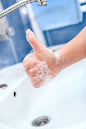 Soapy hand with thumb up. Hand hygiene and protection.の写真素材