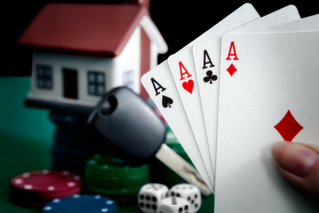 Four aces in hand. House and car keys on card chips.の写真素材