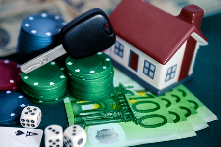 Poker chips with house and car keys, house, money, cards and cubesの写真素材