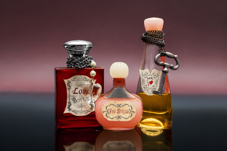 Three bottles with love potion on dark blue surfaceの写真素材