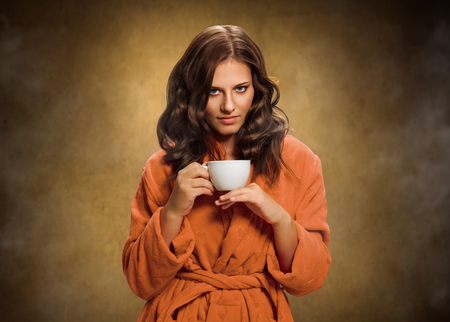 Beautiful young woman with white tea cupの写真素材