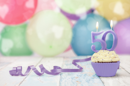 50 anniversary birthday muffin with candle and balloonsの写真素材