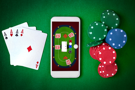 Mobile phone with poker table on screen. Online gambling. Top view.の写真素材
