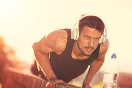 Athletic man doing push-ups in a urban area, outdoor sport, muscular and strong guy exercisingの写真素材