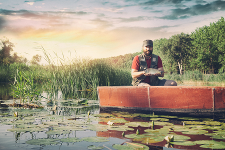 Fisherman. Fishing on the lake or river. Young fisherman holds in hand large catch fish.の写真素材