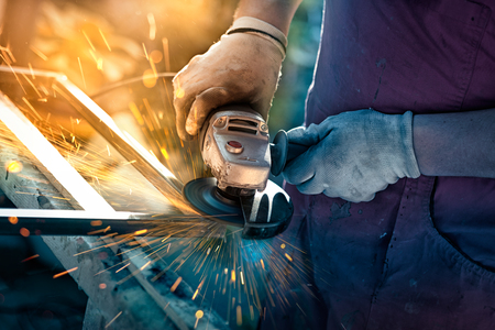 
Craftsman sawing metal with disk grinder in workshopの写真素材