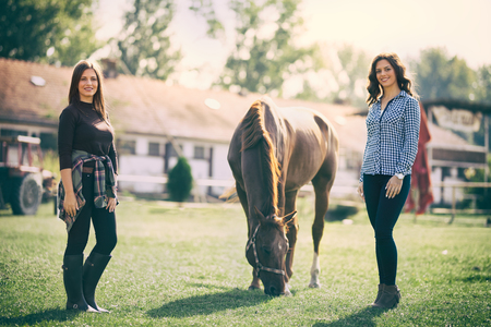 
Two woman on ranch with horse, outdoor in summer happy sunset natureの写真素材