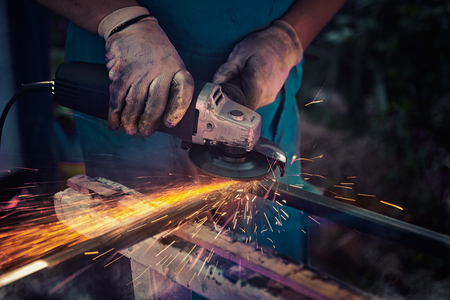 industrial grinding make surface of metal flat producing golden sparks,  master in a workshopの写真素材