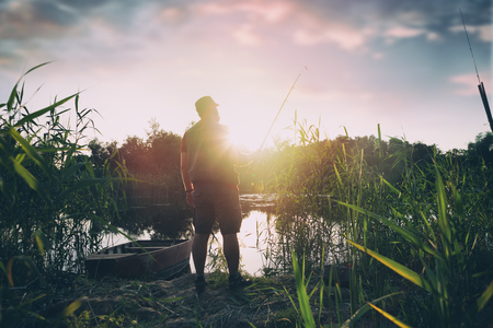 fisherman with fishing rod, lake, men, sport, summer, sunset, water, outdoor, fishの写真素材