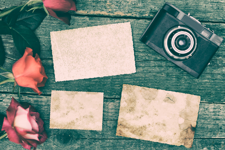 Blank vintage photographs at the wooden desk with retro cameraの写真素材