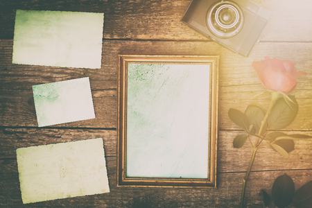 vintage photo frame with retro old photos on wooden table, toned imageの写真素材