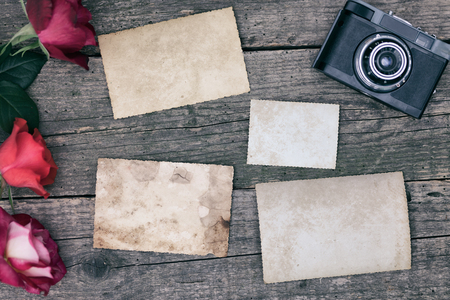 Vintage background with old paper, letters and photos on wooden desk with retro cameraの写真素材