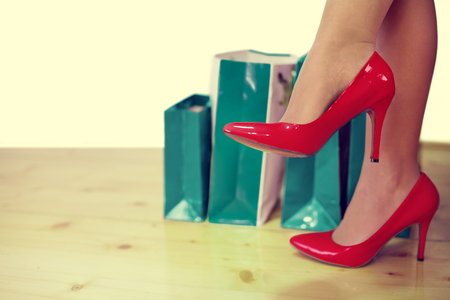 red high heels and shopping bags in background. Shopping breakの写真素材